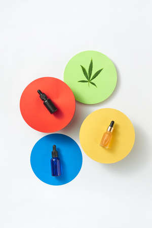 Colorful round cards with bottles of cannabis CBD oil on a light grey background.の写真素材