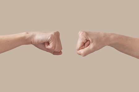 Two hands male and female hands fist bump on beige.の写真素材