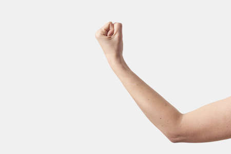 Female arm to shoulder gesturing power and strength on white.の写真素材