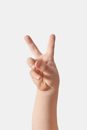 Close up of child hand victory gesturing on white.の写真素材