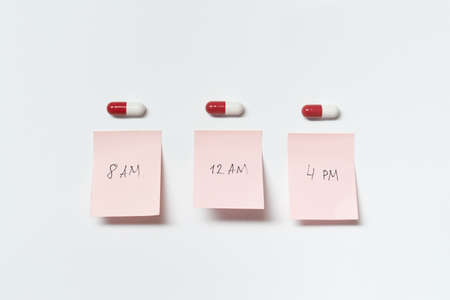 Pharmaceutical pills and medication time notes.の写真素材