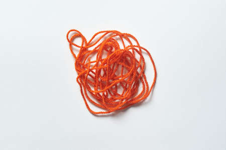 Red tangled thread on white.の写真素材