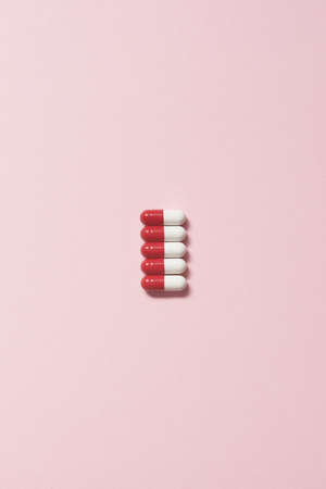Pharmaceutical capsules over pink background.の写真素材