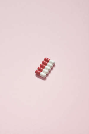 Pharmaceutical tablets over pink background.の写真素材