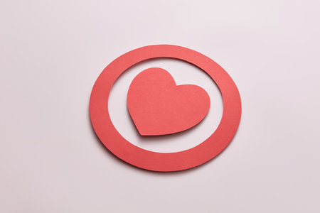 Close-up of red paper heart in circle on beige background with place for text. Creative paper craft design with concept of love.の写真素材