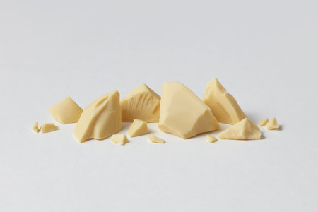 Pieces of organic white chocolate on plain backdrop.の写真素材