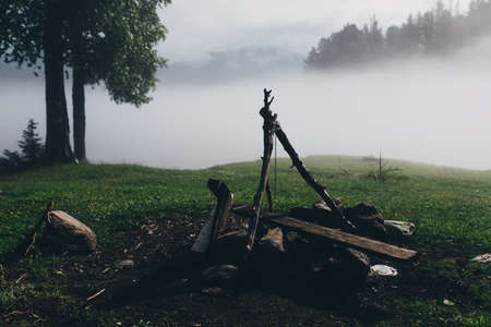 Morning fog in the forest, fireplace with tripodの写真素材