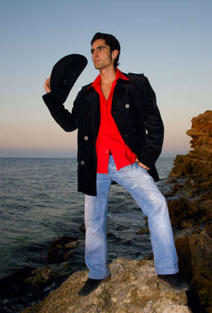 Handsome man is on a beach in hat.
Half-length portrait.
Sunset.
の写真素材
