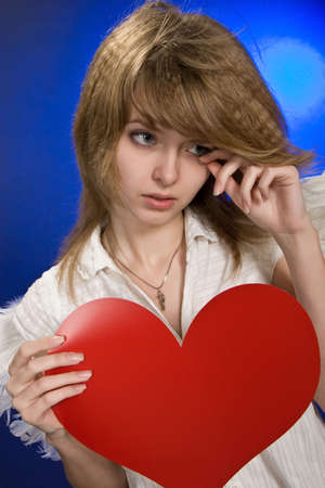 Portrait of beautiful girl with red heart and wings.の写真素材