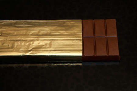 Milk chocolate on black abstract background