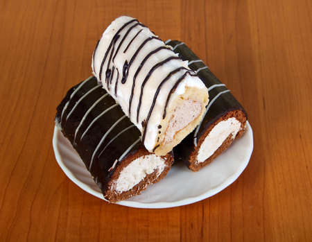 Three small appetizing cakes on white saucerの写真素材