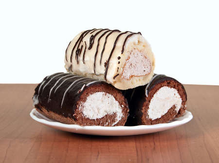 Three small appetizing cakes on white saucer.の写真素材