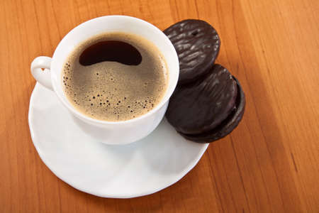 Cup of coffee and chocolate cookies on wooden table.の写真素材