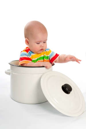Baby sitting in the big white kitchen saucepan. の写真素材