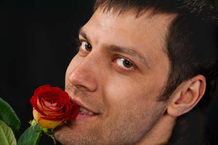Portrait of handsome man with rose on dark background の写真素材