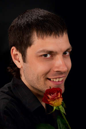 Portrait of handsome man with rose on dark background の写真素材