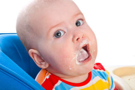 Little baby girl is feeding curds at the tableの写真素材
