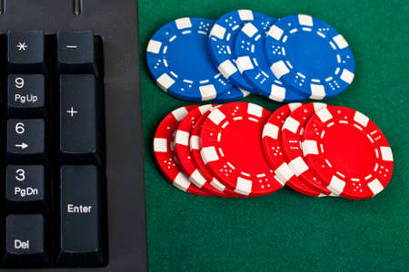 Fragment of the black modern keyboard of computer with gamble chips.の写真素材