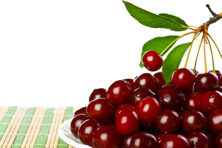 ripe juicy cherries on a white napkin on the grassy saucerの写真素材
