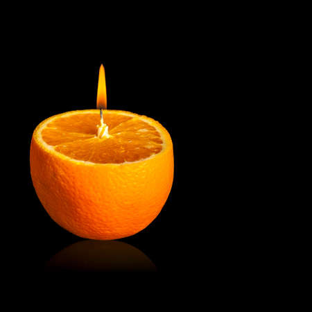 romantic orange -shaped candle isolated on black backgroundの写真素材
