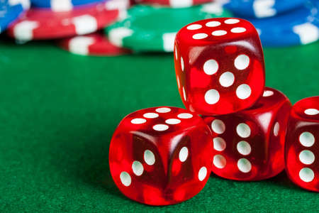 Group of chips and dices on the green cloth.