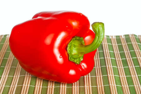 ripe red pepper on cloth straw on white background