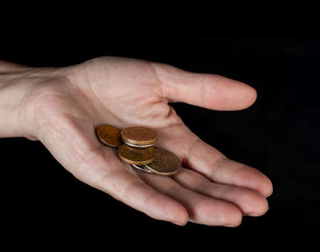 Hand with coins isolated on black の写真素材