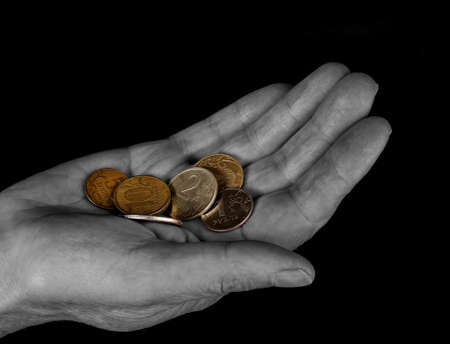 Hand with coins isolated on blackの写真素材