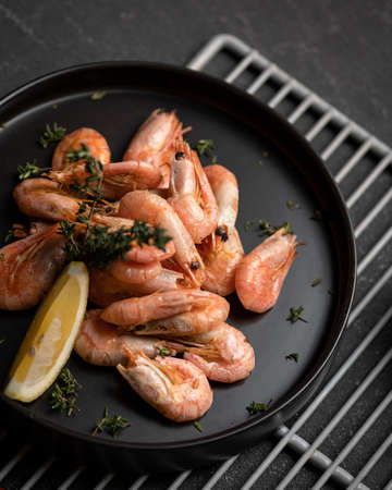 Shrimp lunch with lemon on black background. Seafood plate of Shrimp in asian restaurant. Template...