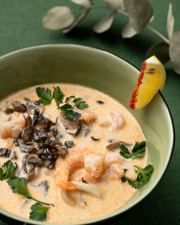 Bowl of Prawns soup. Seafood plate with Shrimp on green background. Asian cuisine concept. Template...