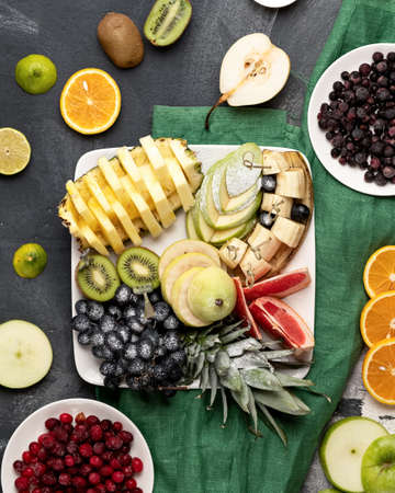 Fresh Organic healthy food set on white square plate. Fruit Assorted mix at table, top view....