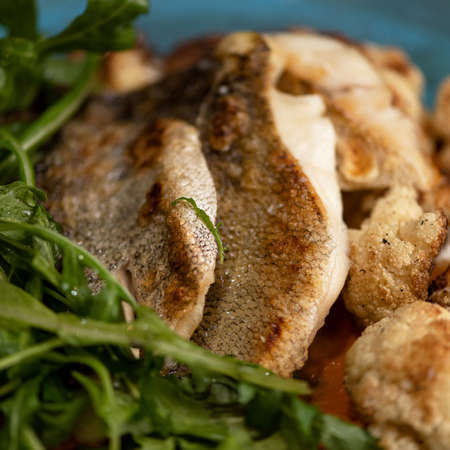 Fried white fish with greens. Close up shot. Food concept.の写真素材