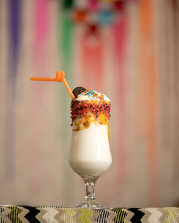 Exotic refreshing milkshake drink in glass goblet. Whipped milk and ice cream cocktail decorated...