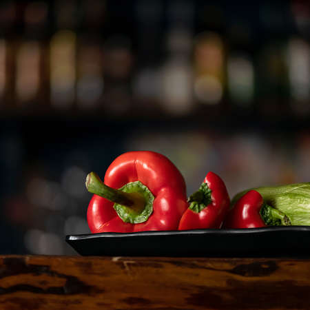 Fresh vegetables. Red bell pepper, capsicum or paprika and zucchini on black blurred background. Organic food concept. Side view. Copy space at top of image. Vitamin products, minimum calorie content.の写真素材