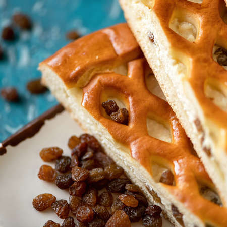 Curd pie and raisins on plate. Homemade pie with cottage cheese. Cooking process. Close up shot. Soft focus. High angle view.の写真素材