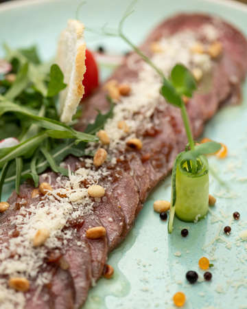 Close-up of cold cuts, meat slices with cucumber roll. Beautiful food serving. Vertical format. Soft focus. Beautiful food serving. Top view. Flat lay. Vertical format.の写真素材