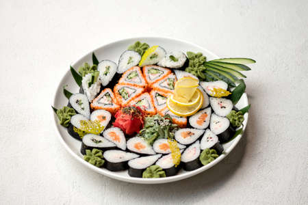 Serving plate with Sushi Set, rolls on white background. Japanese restaurant food. Healthy Oriental meal. Wellness concept. Horizontal format.の写真素材