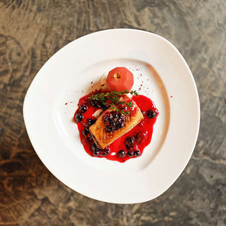 Red appetizer with currant berries on white plate. Beautiful food serving. Top view. Soft focus.の写真素材