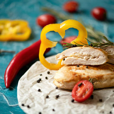 Baked poultry with vegetables. Fried chicken fillet with slices of pepper. Close up shot. Soft focus.の写真素材