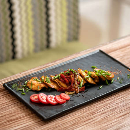 Platter with stewed vegetables and herbs on blurred background. Oriental dinner. Copy space. Pan-asian cuisine, spicy food.の写真素材