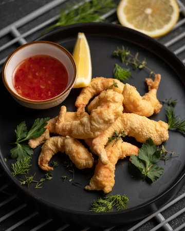 Platter of shrimp fried in batter with parsley and tomato sauce. Pan-asian cuisine, spicy food....