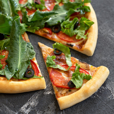 Vitamin Italian pizza with herbs and vegetables. Close-up shot. Sliced vegetarian pizza with spinach, tomatoes and olives. Soft focus.の写真素材