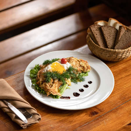 Scrambled eggs omelet with lettuce, tomato and dill. Served breakfast or lunch on wooden table. Soft focus. Copy space.の写真素材