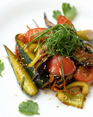 Pickled and fried vegetables with herbs on white background. Autumn salad. Close-up shot. Soft focus.の写真素材