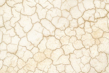 Golden Cracked desert soil. Arid climate. Dry dewatered sandy ground. Abstract texture or background. Horizontal format.の写真素材