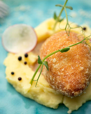 Chicken Kiev, meat cutlet with mashed potatoes and herbs. Close-up shot. Soft focus.の写真素材