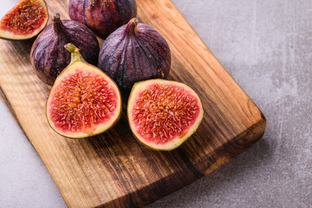 Fresh figs. Whole figs and sliced in half figs on wooden cutting board.
