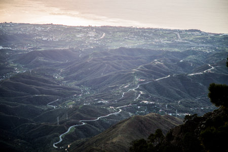 Picturesque view of Spanish green hills with green foliage curve asphalt road amazing coastline of mediterranean sea mountains and beautiful blue sky outdoor, horizontal pictureの写真素材