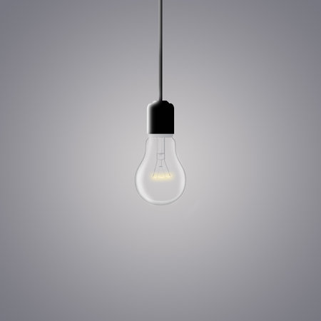 glowing light bulb on a dark gray backgroundの写真素材