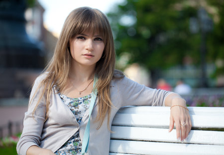 Portrait of a girl. The girl is sitting on a park benchの写真素材